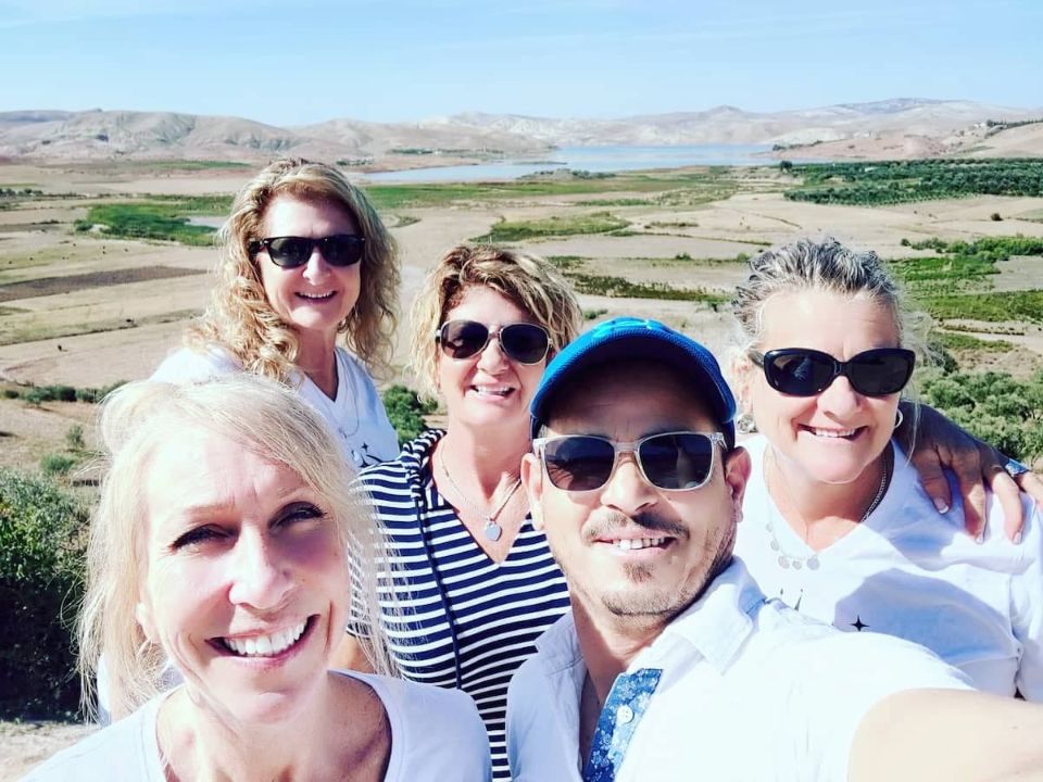 Group of travelers taking a selfie during a private Morocco tour with scenic landscapes